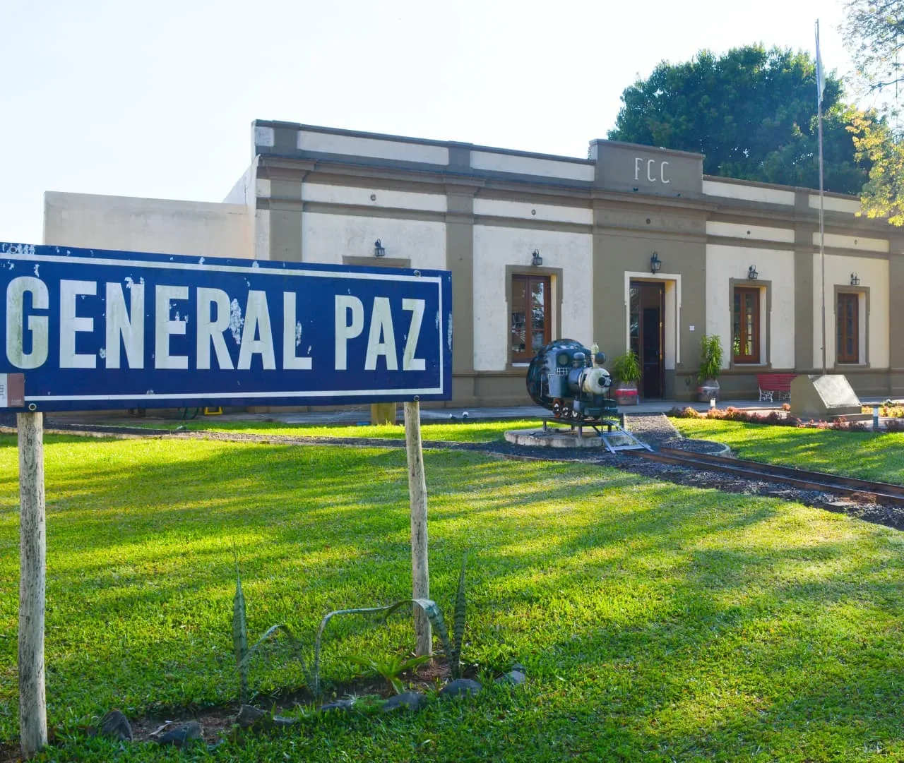Cartel de la Estación General Paz frente al edificio restaurado del ferrocarril