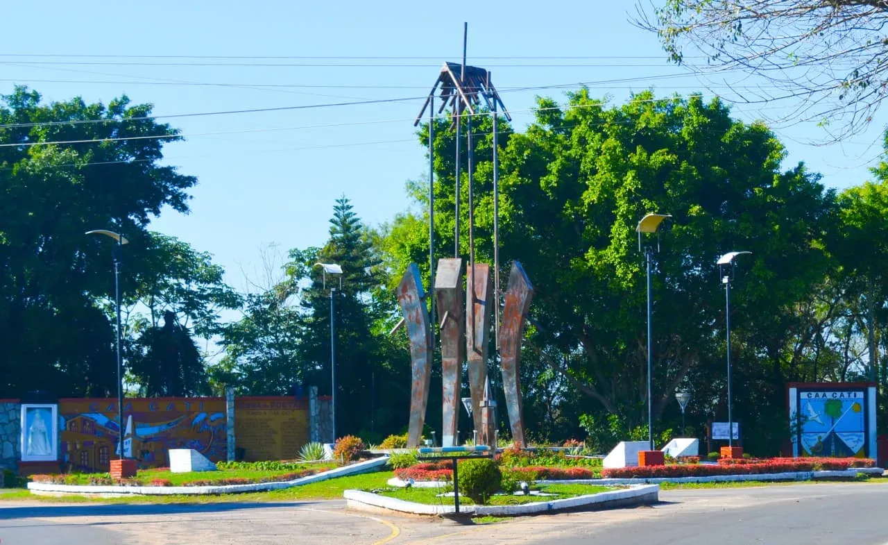 Escultura y canteros con flores en el ingreso a Caá Catí