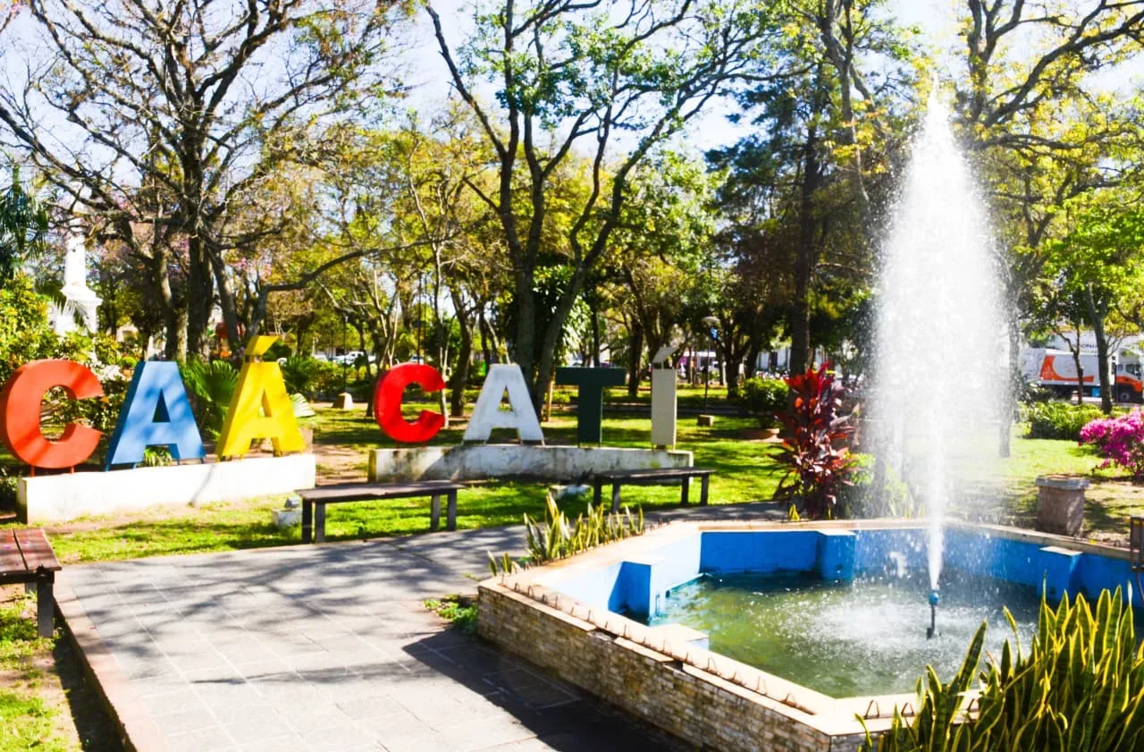Letras de colores de Caá Catí en la plaza, junto a una fuente de agua